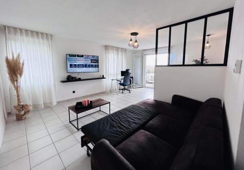 un salon avec un canapé et une table dans l'établissement Lormont City, proche Bordeaux, piscine et parking, à Lormont