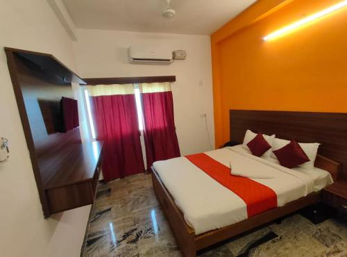 a bedroom with a bed with a red curtain at Hotel New Cresent park in Coimbatore