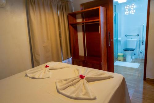 a bedroom with a bed with two towels on it at Vila Feliz - Chalés completos - ideal para famílias in Serra de São Bento