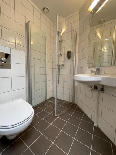 La salle de bains est pourvue de toilettes et d'un lavabo. dans l'établissement P-Hotels Oslo, à Oslo