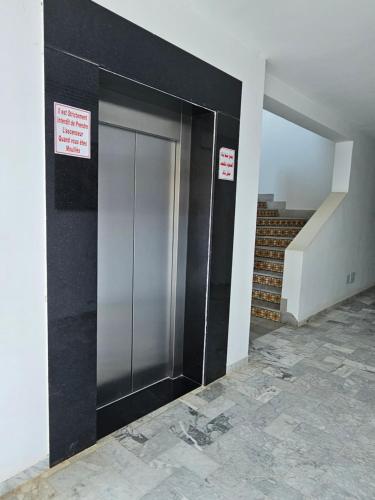a elevator in a building with two signs on it at Villa Jasmin Super equipped apartment with Garden, Swimming pool, Sea in Hammamet