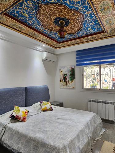- une chambre avec un grand lit et un plafond peint dans l'établissement Villa Jasmin Super equipped apartment with Garden, Swimming pool, Sea, à Hammamet
