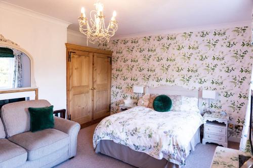 a bedroom with a bed and a chair and a chandelier at Kateshill House Bed & Breakfast in Bewdley