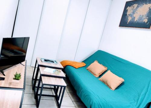 łóżko w pokoju ze stołem i kanapą w obiekcie Studio la belle échappée 2pers Centre-ville/Fibre w mieście Millau