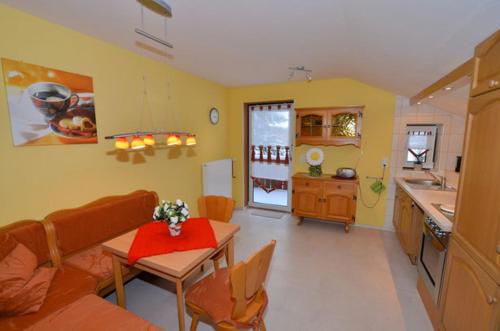 a living room with a table and a kitchen at Haus Rosenbühl in Warmensteinach