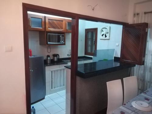 eine Küche mit einer schwarzen Arbeitsplatte in einem Zimmer in der Unterkunft Oásis Tropical: Flat de Luxo na Beira, Moçambique in Beira