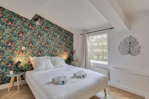 une chambre avec un grand lit blanc avec un papier peint fleuri dans l'établissement Appartement Cosy proche Arc Triomphe - 2P, à Paris