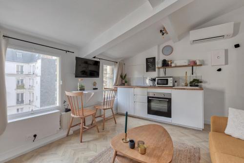 a kitchen and living room with a couch and a table at Appartement Cosy proche Arc Triomphe - 2P in Paris