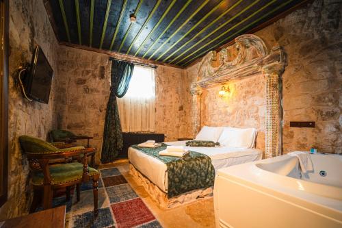 a bedroom with a bed and a tub in a room at Lunas Cappadocia in Nevşehir