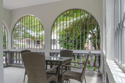 a table and chairs on a balcony with windows at La Fattoria Resort in Mombasa
