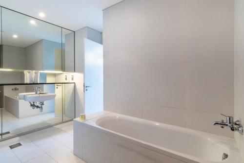 杜拜的住宿－Silkhaus contemporary 1BDR with Downtown view in DIFC，白色的浴室设有浴缸和水槽。