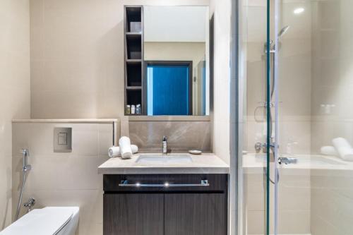 La salle de bains est pourvue d'un lavabo et d'une douche en verre. dans l'établissement Silkhaus homely 2BDR with stunning Downtown view with Balcony, à Dubaï