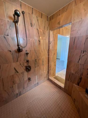 a bathroom with a shower with a tiled floor at Cozzy Apartment on the Caribbean side-Frigate Bay in Frigate Bay