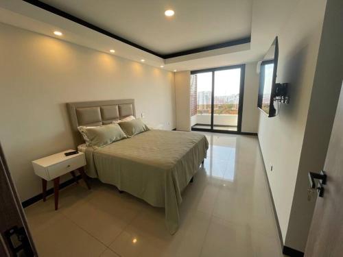 ein Schlafzimmer mit einem Bett und einem großen Fenster in der Unterkunft Hermoso Depto Penthouse in Santa Cruz de la Sierra