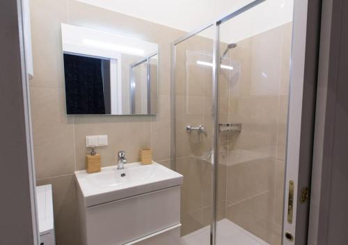 een badkamer met een wastafel en een glazen douche bij Justus I levestate in Wenen