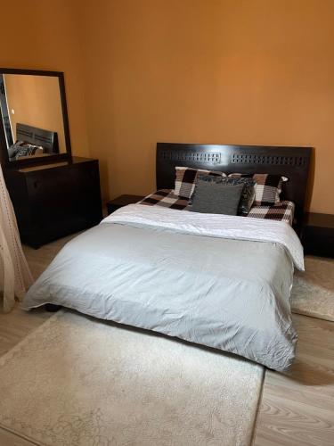 a bedroom with a large bed with white sheets and pillows at cosy Furnished appartment in Ez Zahra