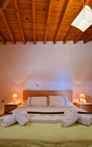 a bedroom with a large bed with two lamps at Yiannis Village house in Asklipiḯon