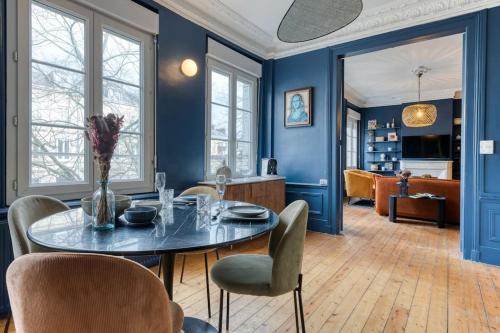 une salle à manger avec des murs bleus et une table et des chaises dans l'établissement Appartement balnéo centre, à Rouen