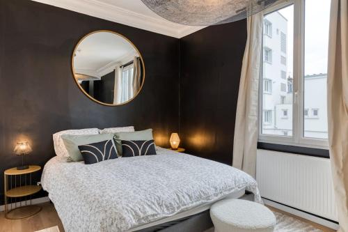 une chambre avec un grand lit et un miroir dans l'établissement Appartement balnéo centre, à Rouen