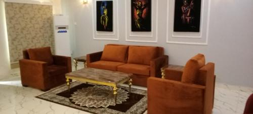 a living room with two chairs and a coffee table at 778 Stone House Apartment in Gwarinpa