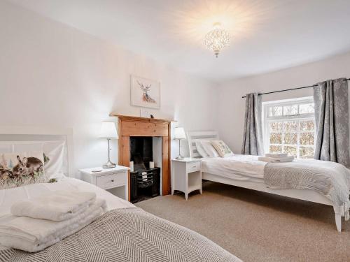 1 dormitorio con 2 camas y chimenea en 2 Bed in Slimbridge 90719 en Cambridge