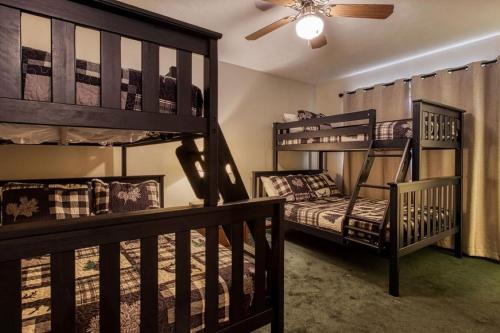 a bedroom with two bunk beds and a ceiling fan at Pool-Pinecrest Townhomes-1KING 2BUNK UNIT in Pigeon Forge