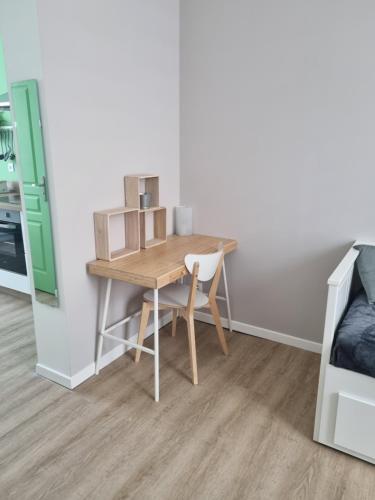 - une table et une chaise dans une chambre avec un lit dans l'établissement La Cigale, à Soissons