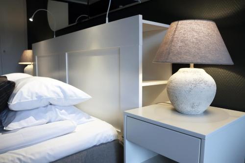 a lamp on a night stand next to a bed at Hotell Miskarp in Mjölby
