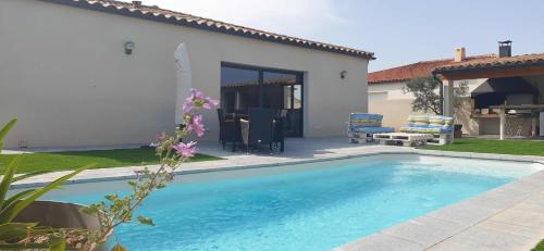 una piscina di fronte a una casa di Villa de 3 chambres avec piscine privee jardin clos et wifi a Pia a Pia