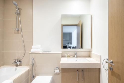 a bathroom with two sinks and a tub and a mirror at Silkhaus with marina & beach view 1BDR near Bluewaters Island in Dubai