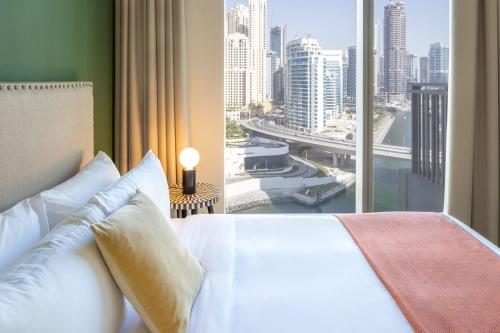a bedroom with a bed and a large window at Silkhaus with marina & beach view 1BDR near Bluewaters Island in Dubai