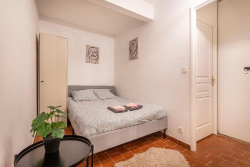 une petite chambre avec un lit et une table dans l'établissement Charmant Studio au Cœur du Centre Historique, à Aix-en-Provence