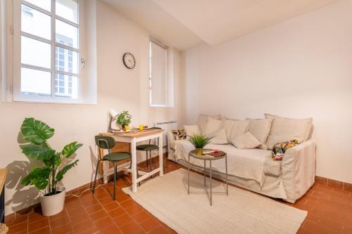 un salon avec un canapé et une table dans l'établissement Charmant Studio au Cœur du Centre Historique, à Aix-en-Provence
