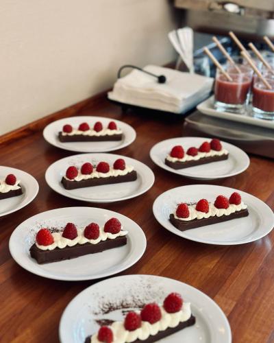 a table topped with white plates topped with cakes and strawberries at Hotell Miskarp in Mjölby