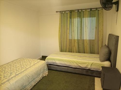 ein kleines Schlafzimmer mit 2 Betten und einem Fenster in der Unterkunft La petite Kasbah in Marrakesch