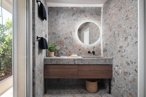 a bathroom with a sink and a mirror at Modern Seafront Villa Steps from the Beach in Rogoznica