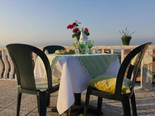 een tafel met een witte tafeldoek en bloemen erop bij Terrazza sul Mare in Fano