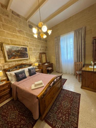 ein Schlafzimmer mit einem großen Bett in einem Zimmer in der Unterkunft B&S Accommodation 1940 House of Character in Żejtun