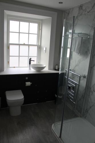 a bathroom with a shower and a toilet and a sink at Conon Hotel in Dingwall