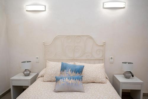 a bedroom with a white bed with two night stands at Villa Yasmin Blue in Muro