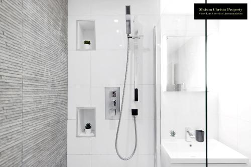 a white bathroom with a shower and a sink at Caraway Heights 2Bedroom Apt Sleeps 6 in Canary Wharf, London with Free Parking, Wifi & Leisure By Maison Christo Property Short Lets & Serviced Accommodation in London