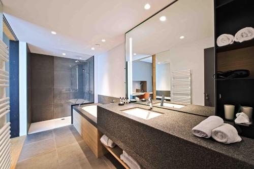 a bathroom with a sink and a large mirror at Domaine de Naxhelet in Wanze