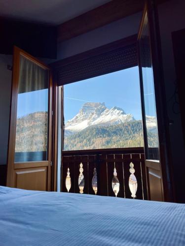 a bedroom with a view of a snow covered mountain at Hotel Oasi in San Vito di Cadore