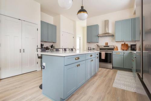 a large kitchen with blue cabinets and white appliances at The Modern Rustic in Indianapolis