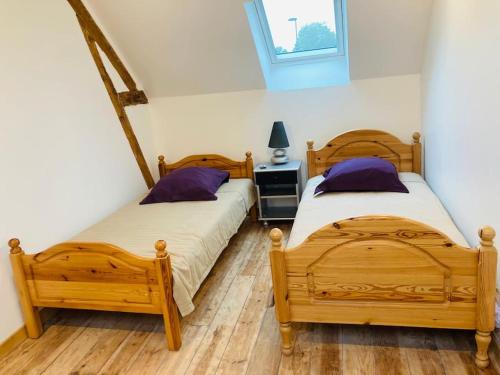 - 2 lits en bois dans une chambre avec fenêtre dans l'établissement le relais du chatô, à Quend