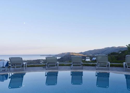 eine Gruppe von Stühlen neben einem Pool in der Unterkunft Villa Lindos Star in Rodos with Private pool in Kalathos