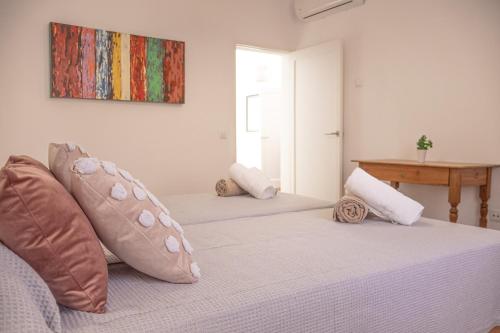 1 Schlafzimmer mit 2 Betten mit Kissen und einem Tisch in der Unterkunft Son Moro 269 by Mallorca Charme in Muro