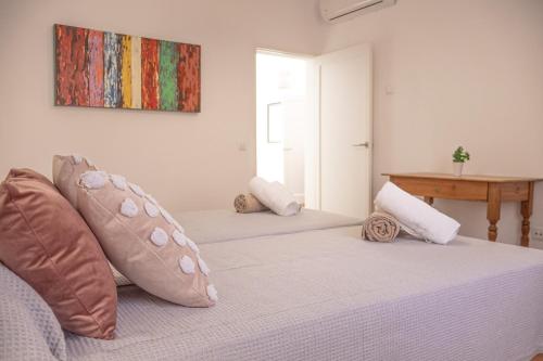 a bedroom with two beds with pillows and a table at 269 Son Moro ETV7750 by Mallorca Charme in Muro