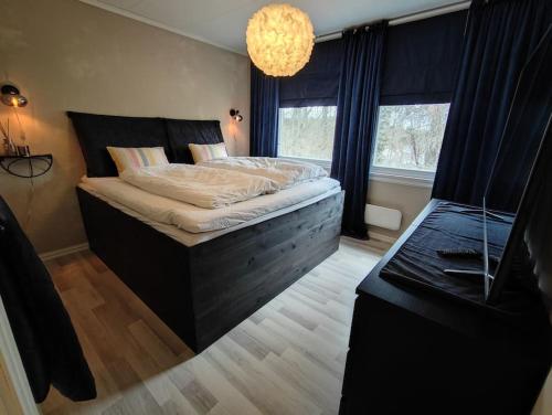 a bedroom with a large bed with a large window at Sentral familievennlig bolig med hage og uteplass in Arendal