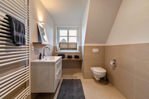 a bathroom with a toilet and a sink and a window at Mynreet in Tating